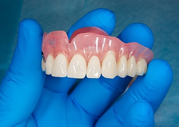 lab tech holding dentures in South Windsor 