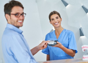 Dental receptionist helping patient in South Windsor