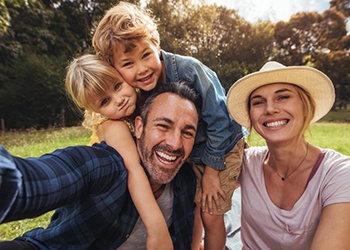 family of four sitting in a park 