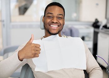 Happy dental patient making thumbs-up gesture