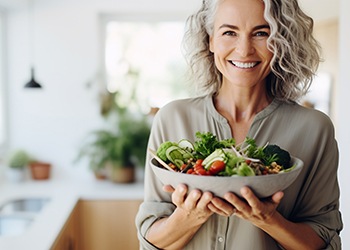 Middle-aged woman holding a colorful salad