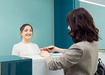 Patient providing payment at dental office front desk