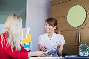 dental team member showing paperwork to a patient