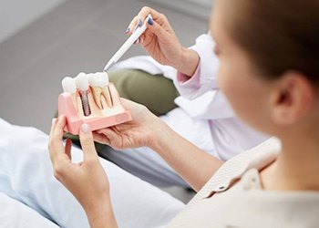 dentist showing a patient how dental implants work