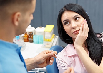 Woman holding cheek in pain