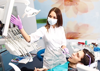 Man in dental chair looking at images on computer