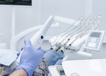 Happy dental patient holding hand mirror