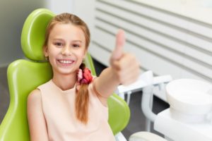 little girl smiling happily at dentist