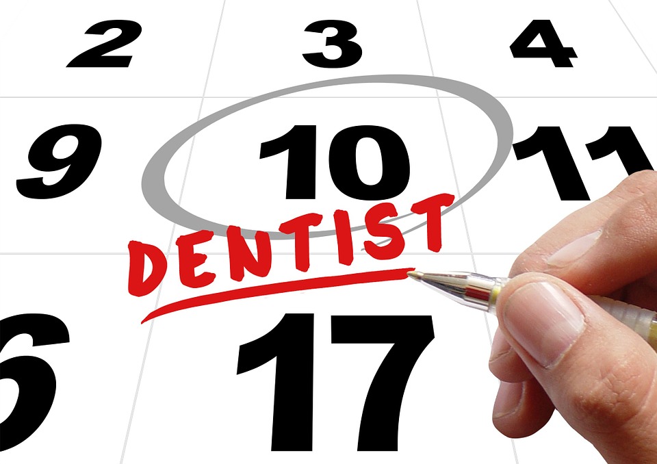 person’s hand circling the word “dentist” on calendar